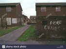 run-down-council-housing-estate-more-drugs-the-no-is-painted-out-sign-A966N4.jpg